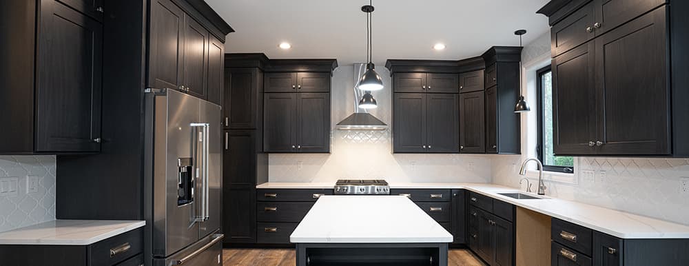 Newly renovated kitchen with dark cabinets to contrast white countertops and walls, with lots of natural light representing Advantage Construction's kitchen remodeling contractor service they offer in Las Vegas, NV.