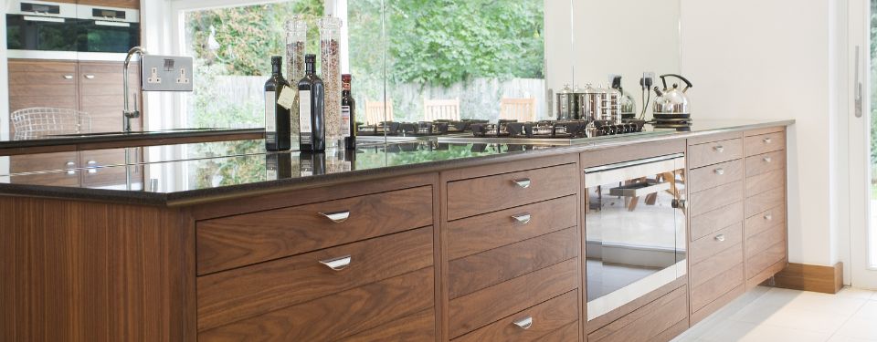 Wooden kitchen cabinets with a stove and faucet on top.