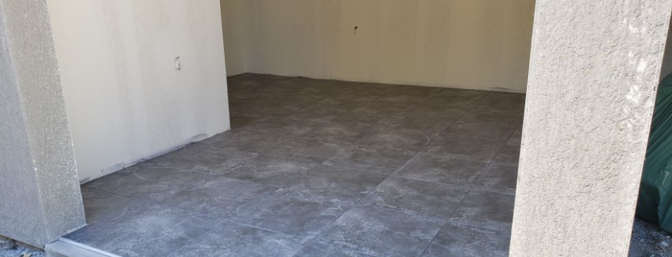Newly laid tile to improve a commercial space for a tenant.